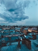 A cinematic frame from a feature film showing a dramatic cityscape at dusk.