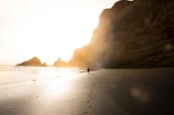 man on shore near rock formation