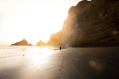 man on shore near rock formation