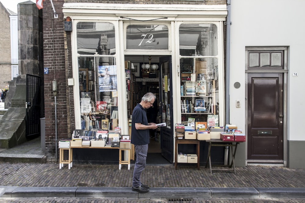 man standing in front of a bookshop