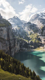 Clean horizon shot of a glacier blue alpine lake surrounded by forested slopes.