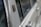 Close-up view of a section of a classic car's exterior, highlighting the shiny metal surface and textured details near the window area.