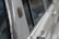 Close-up view of a section of a classic car's exterior, highlighting the shiny metal surface and textured details near the window area.