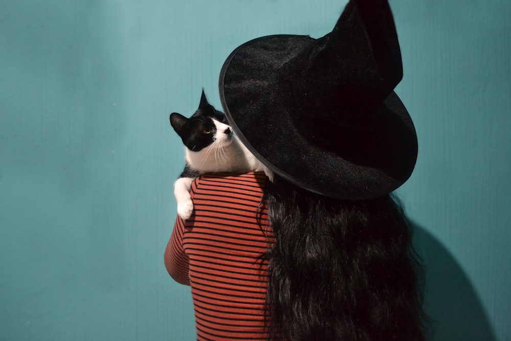 woman carrying tuxedo cat