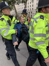 four policemen carrying men