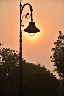 A serene sunset glowing over a quiet, cobblestone street framed by vintage lampposts.