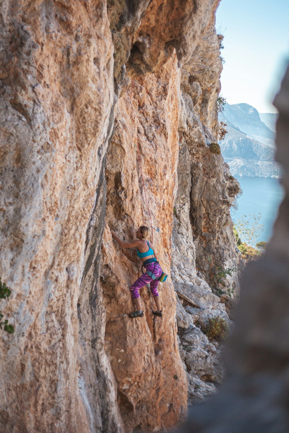 woman climbs up the cliff at daytime