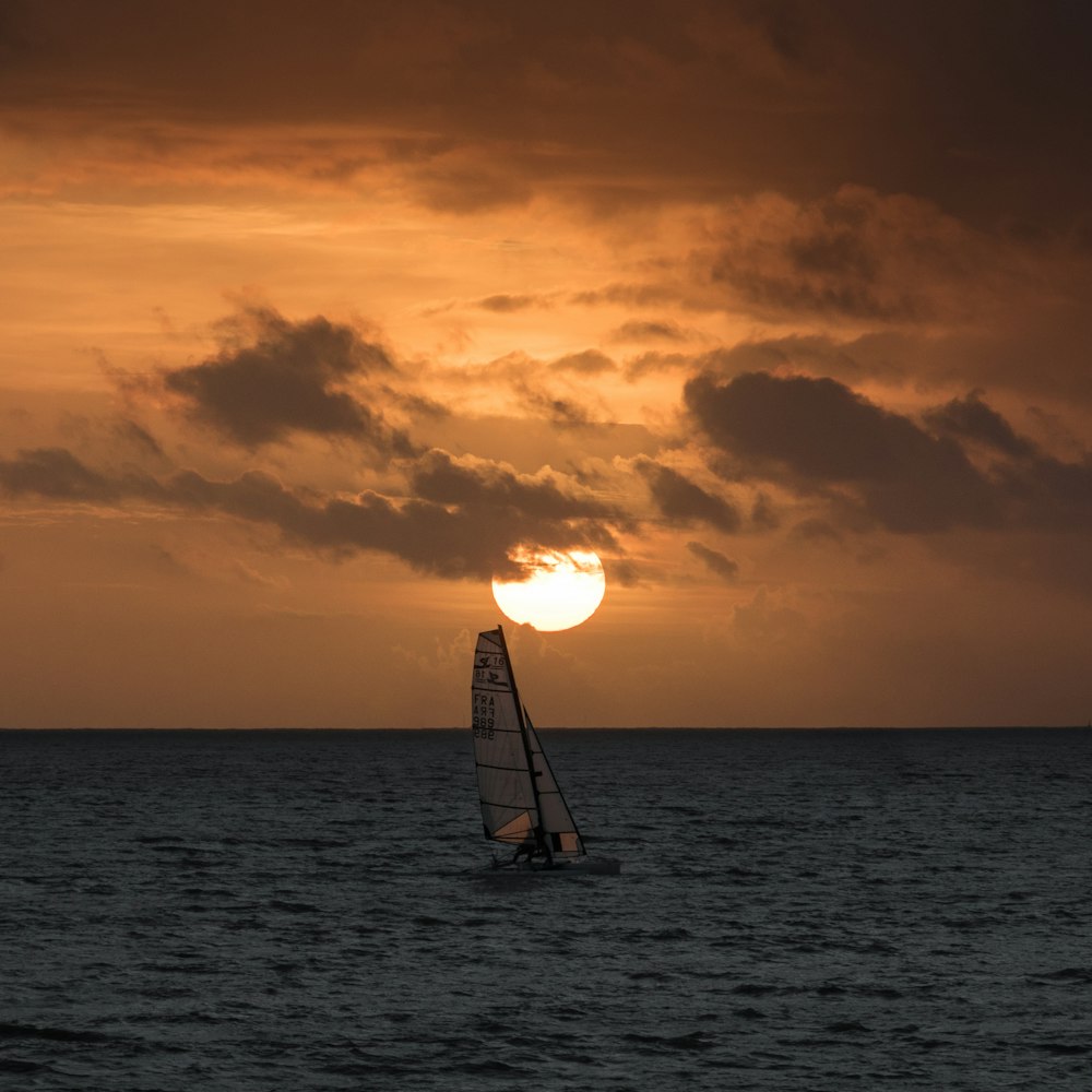 barca a vela grigia sull'oceano durante il giorno