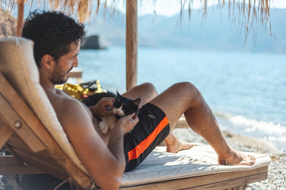 man sits on lounger near shore