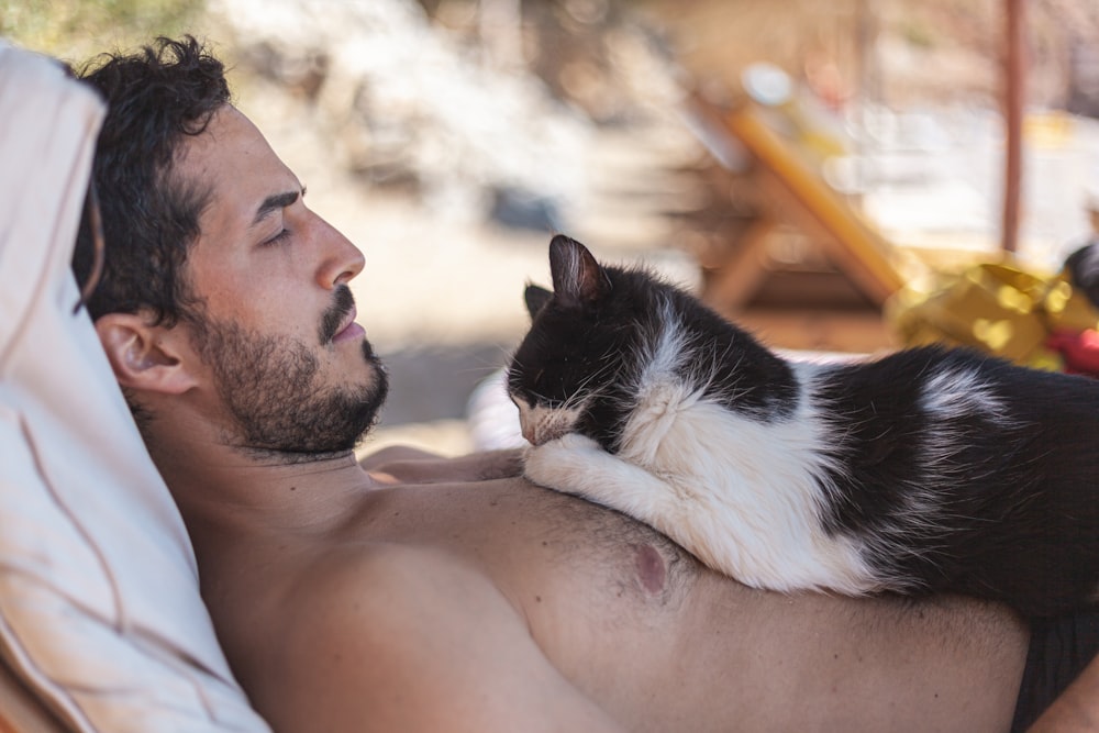 cat lying on topless man