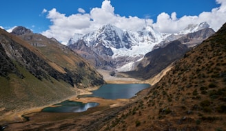 blue body of water between mountain during daytime