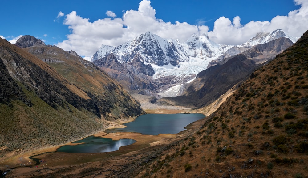 blue body of water between mountain during daytime