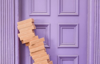 pile of brown boxes beside purple wooden wall