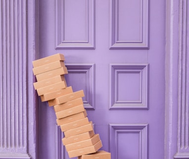 pile of brown boxes beside purple wooden wall