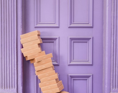 pile of brown boxes beside purple wooden wall