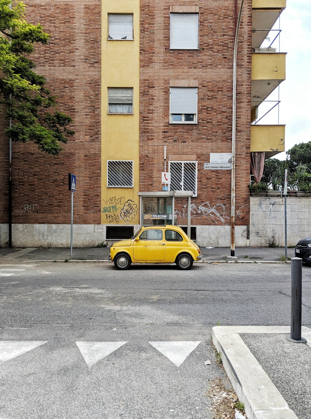 yellow vehicle beside brown brick building