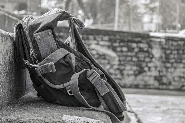 A rugged tactical backpack designed for one person, shown outdoors with survival gear.