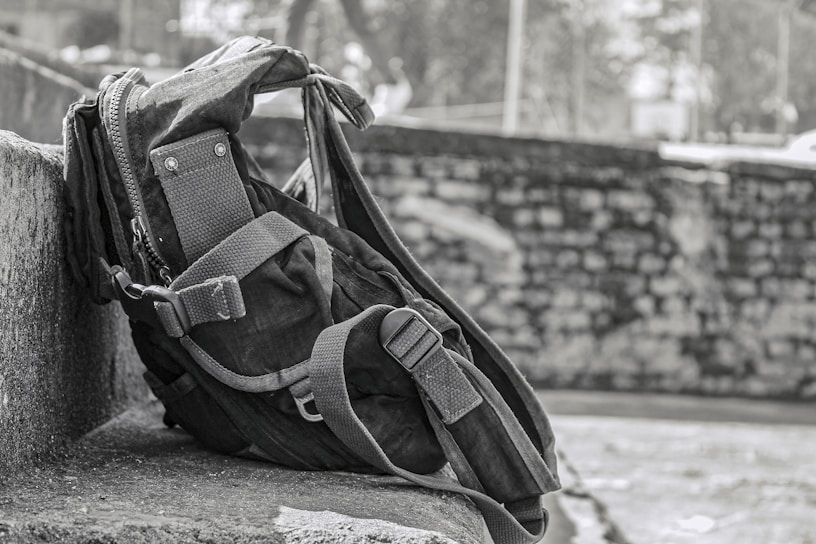 A sleek, durable travel backpack resting on a wooden bench with a scenic mountain backdrop.