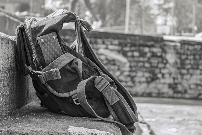 Front view of a rugged, waterproof backpack with multiple compartments open, showing layered storage.