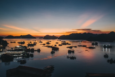 Sunset view over Samaná Bay with silhouettes of limestone hills and boats returning to port.