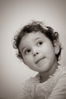 Portrait of Cecilia, a young child actress from Tbilisi, smiling warmly with a softly lit background.