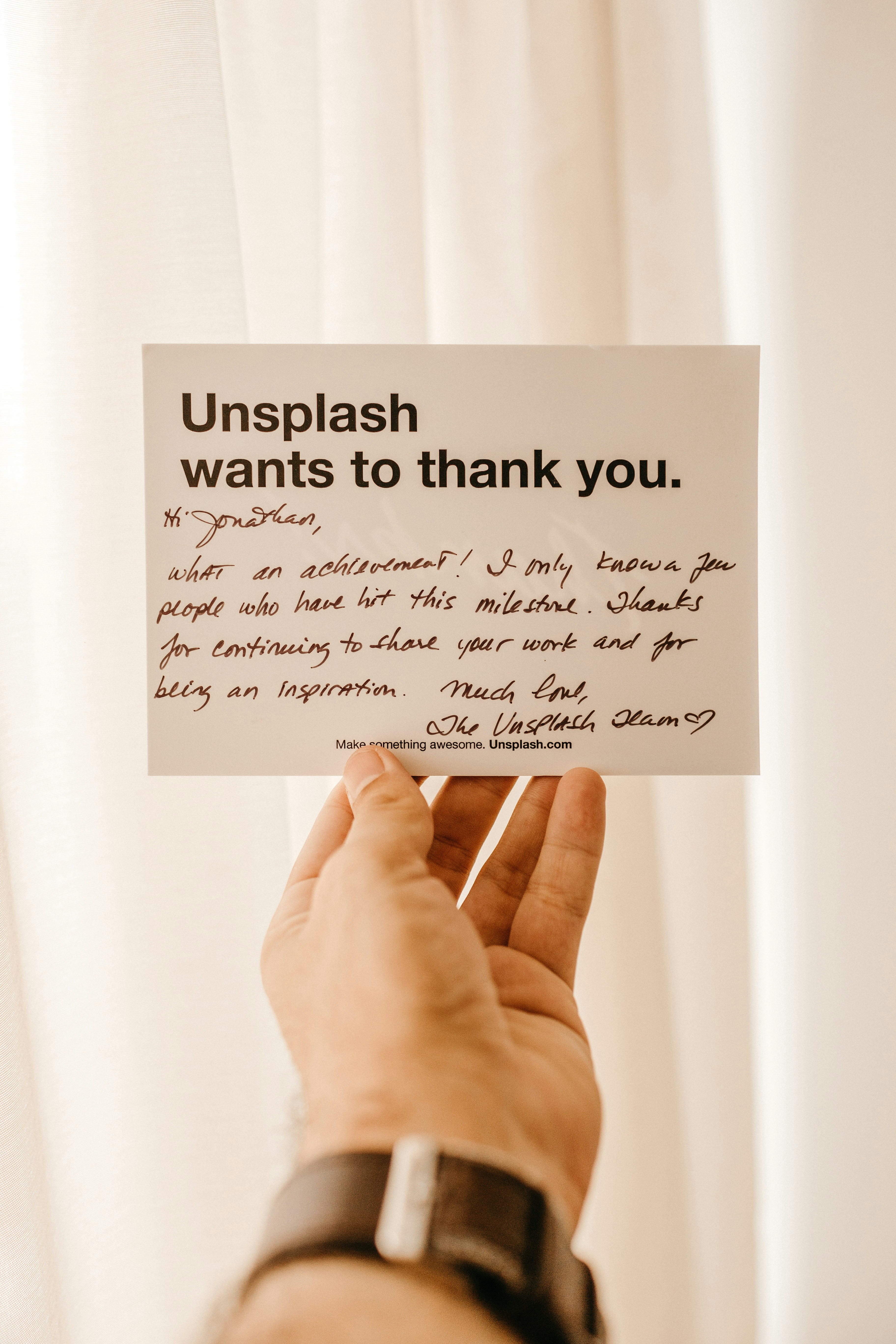white card with "Unsplash wants to thank you" printed on it