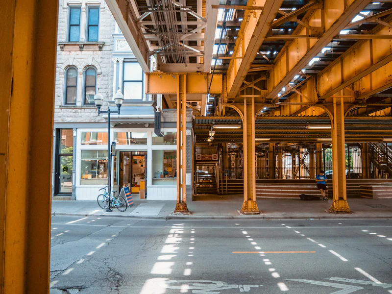 A bicycle parked beside a lamppost with the CTA 'L' train in Chicago's Old Town
