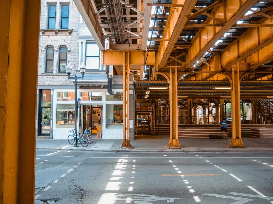 bike parked beside lamppost and buildings during day, The El