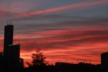 A traveler capturing a sunset over a vibrant city skyline with red and white lights.