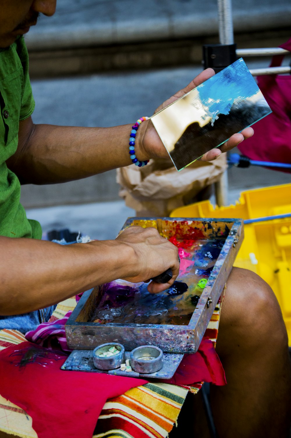 a man sitting on a chair painting a picture