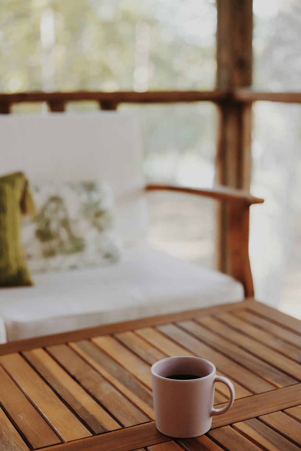 a cup of coffee sitting on top of a wooden table