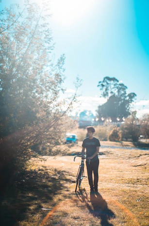 Happy cyclist holding a recovered bike with a nanotag tracker visible on the frame under natural light.