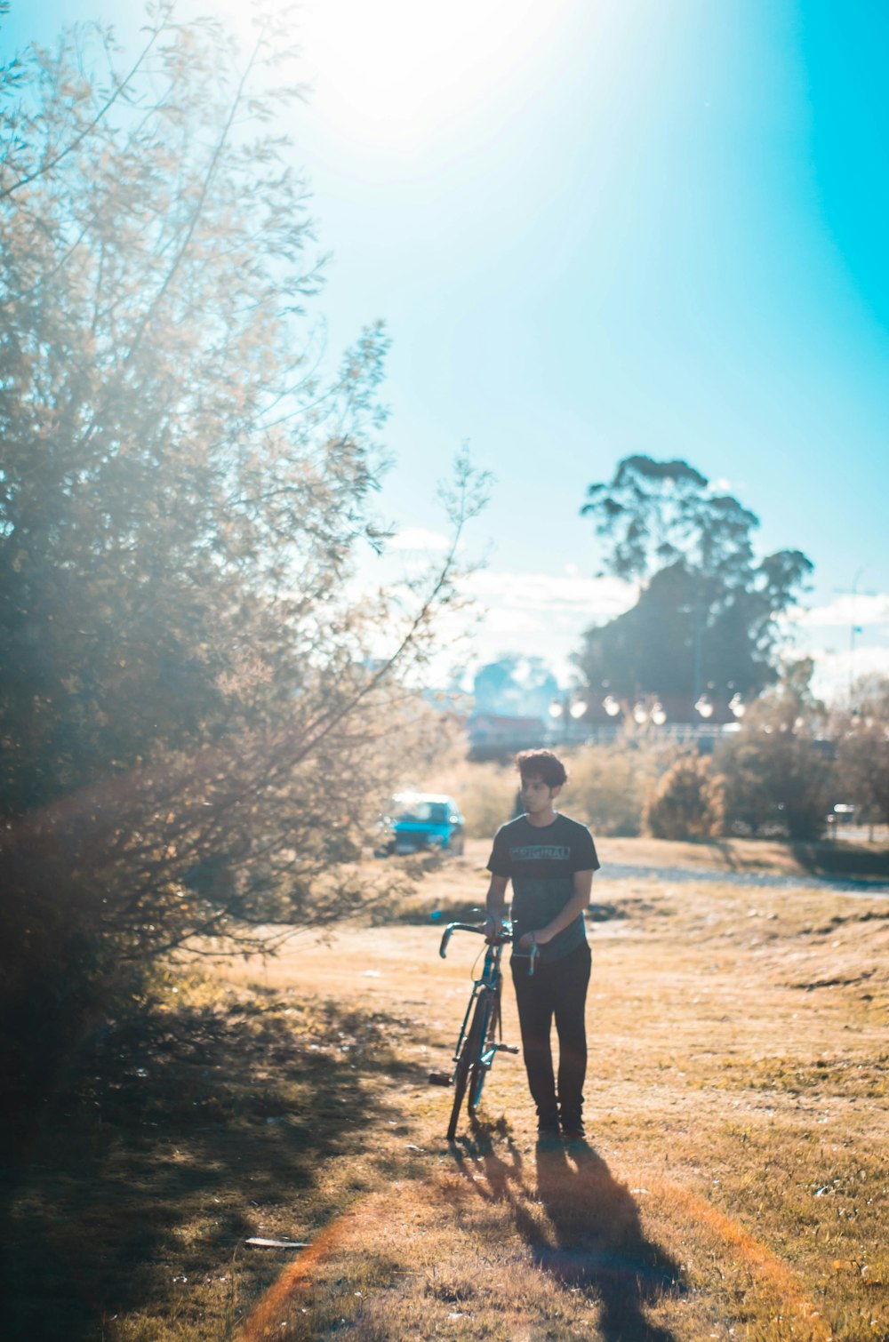 man standing beside bike and tree