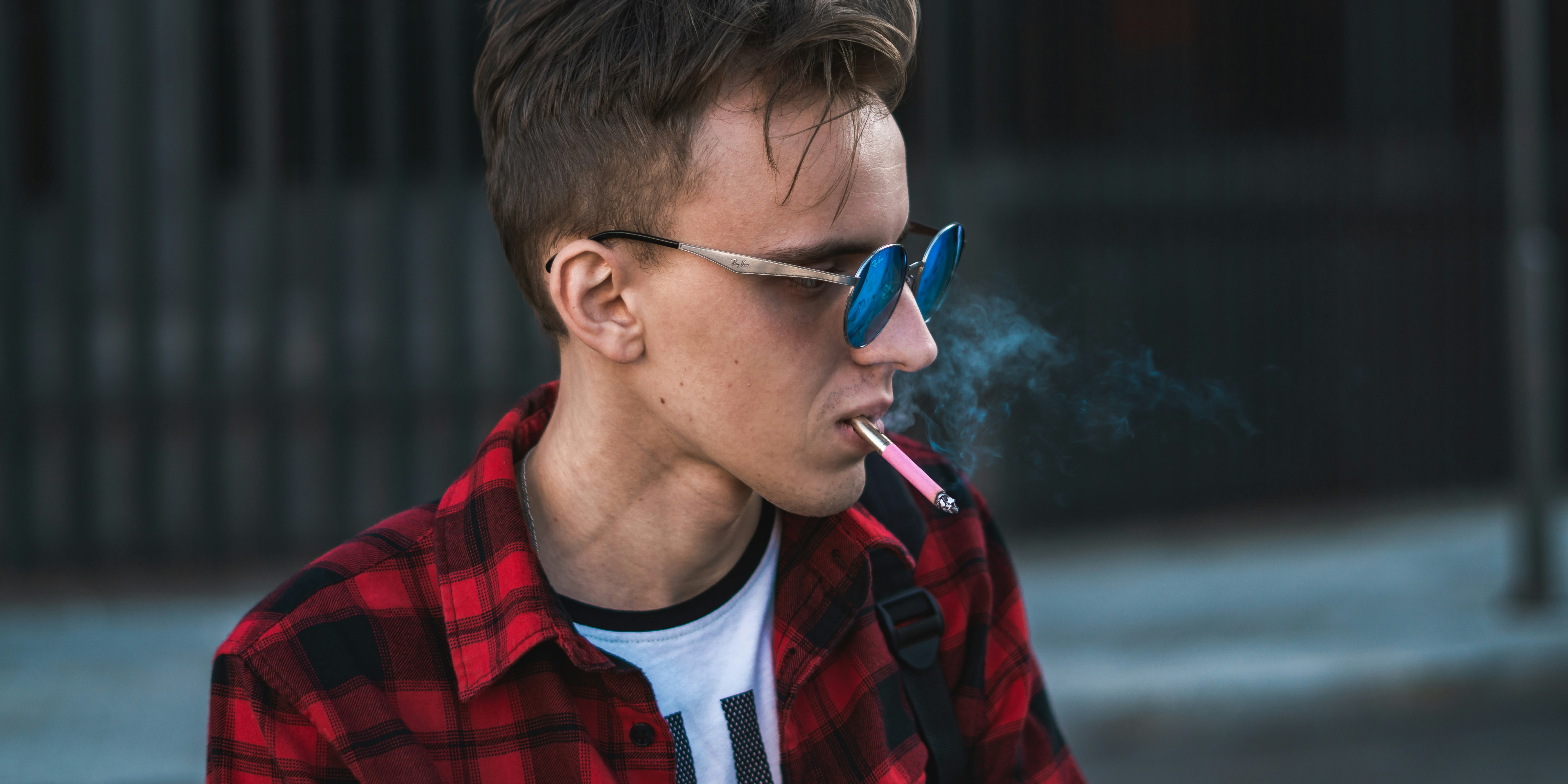 man smoking near wall