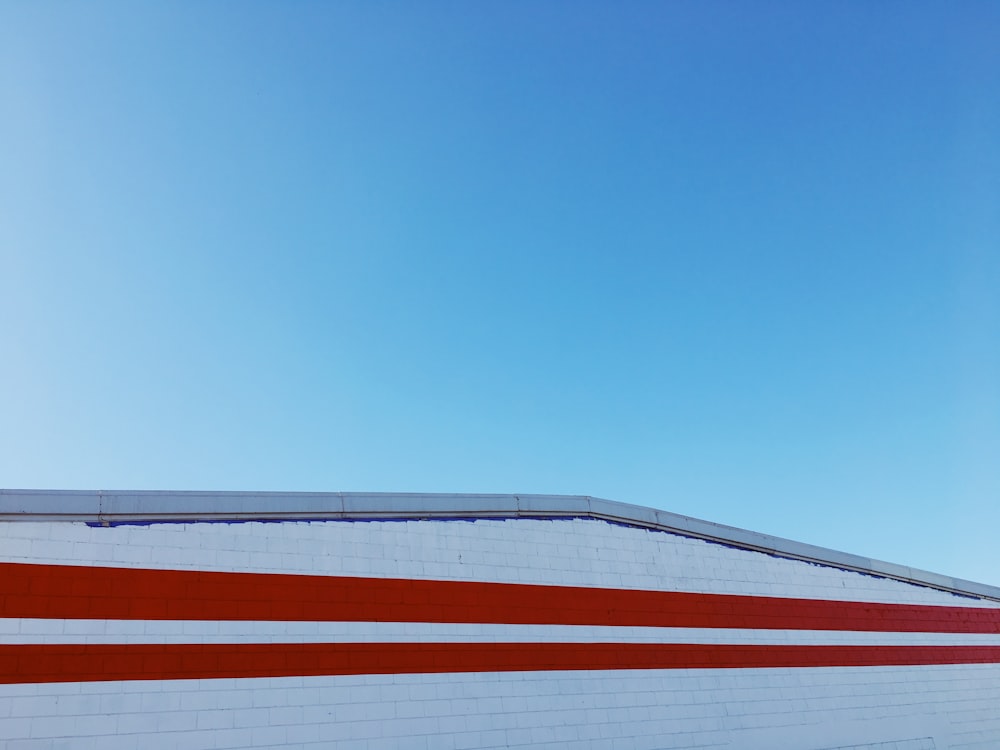 bâtiment en béton blanc et rouge sous ciel bleu et blanc pendant la journée