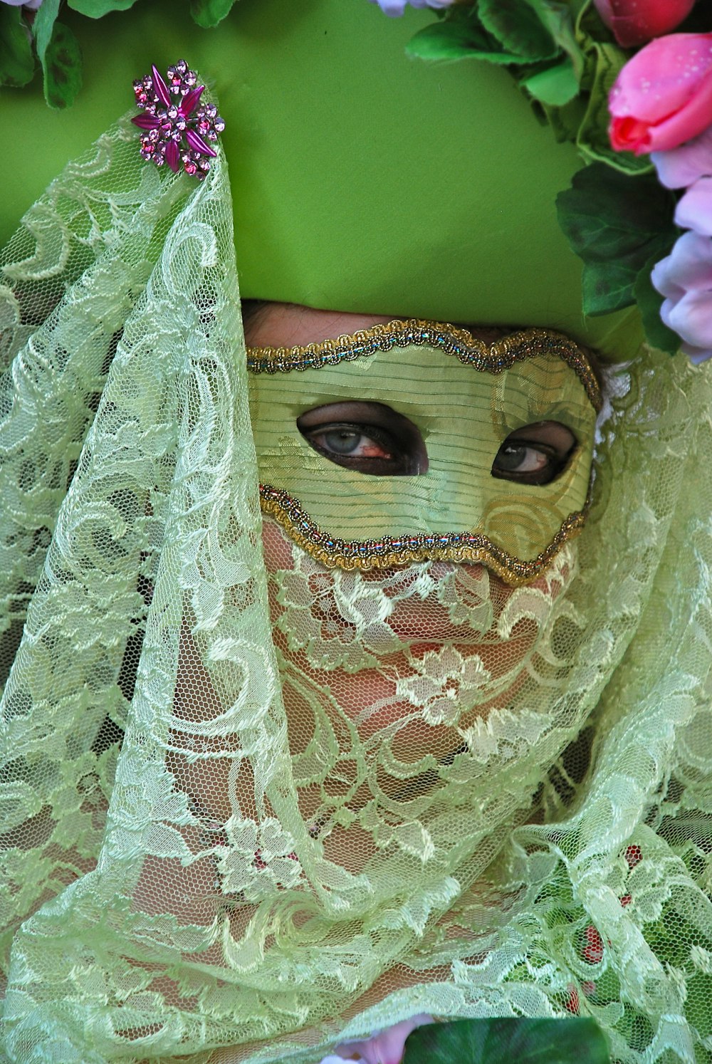 woman wearing green mesh hat and masqueraded mask