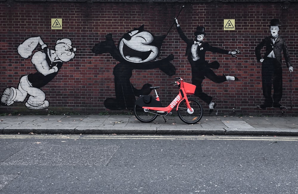 bike parked on sidewalk with graffiti filled wall