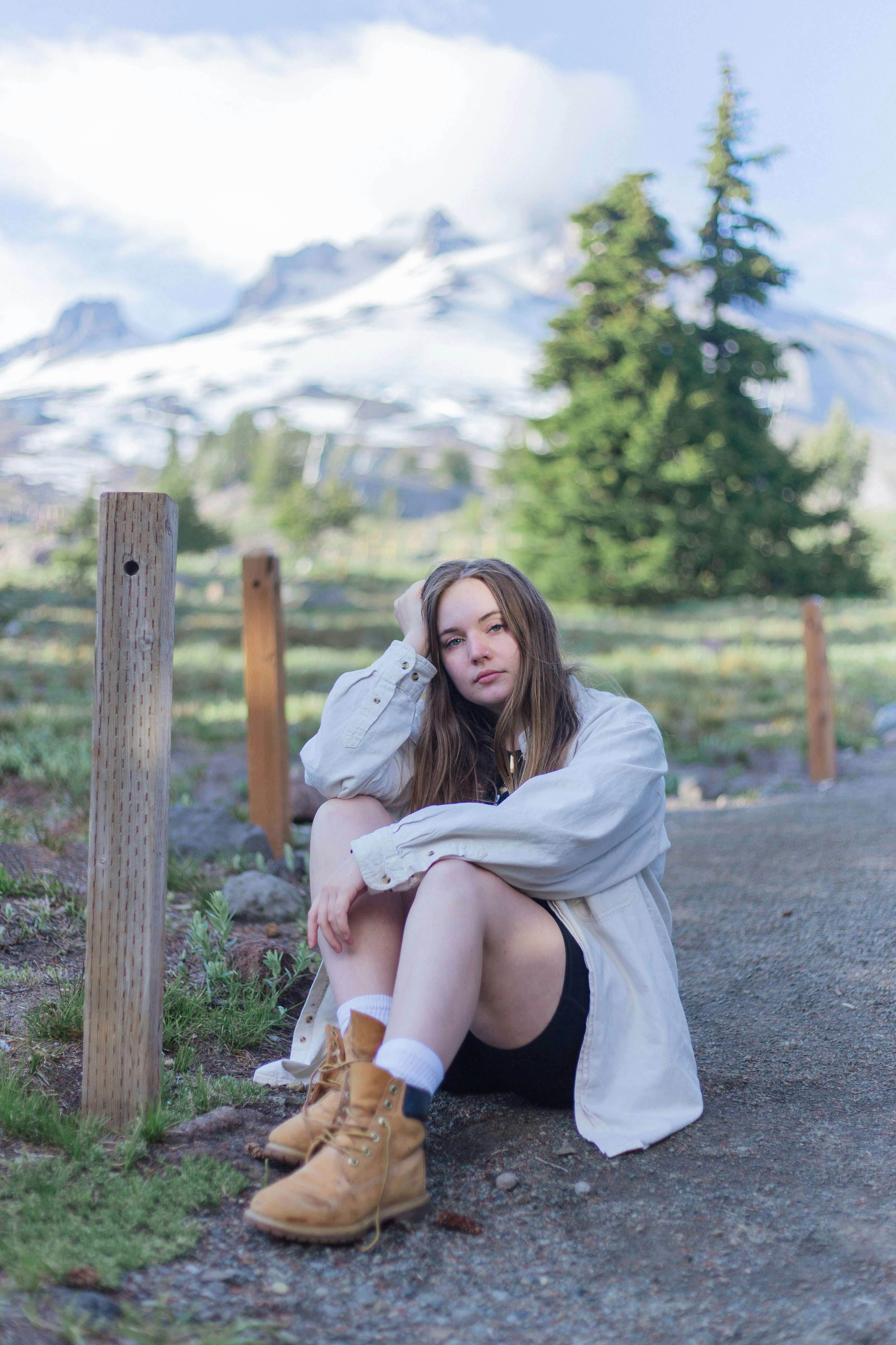woman wears blue cardigan sits on the field