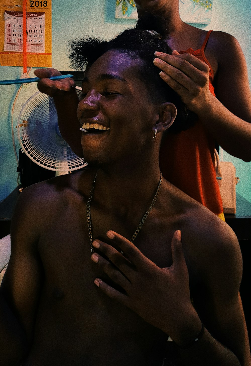 person standing near laughing man while fixing hair