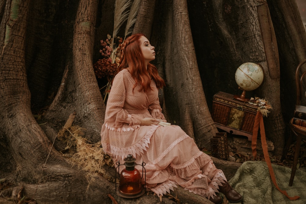 woman sitting beside big tree and lamp