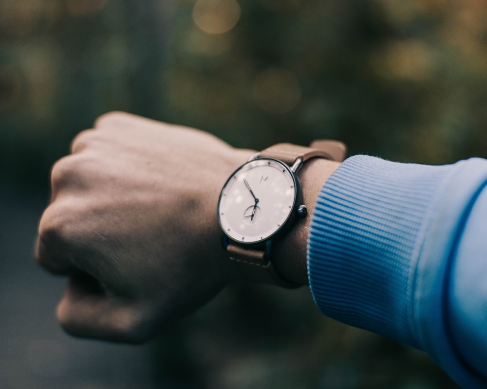 round black analog watch with brown strap