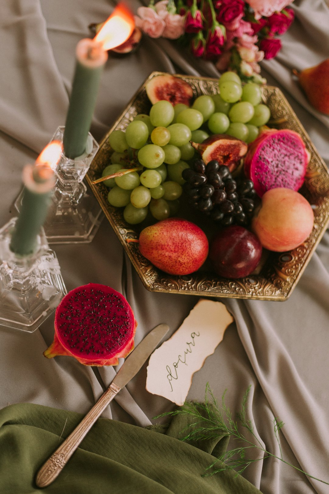 assorted fruits in bowl near lighted green candles