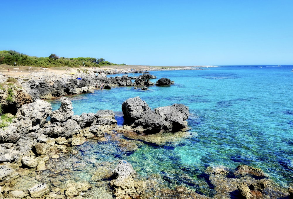 gray stones beside body of water