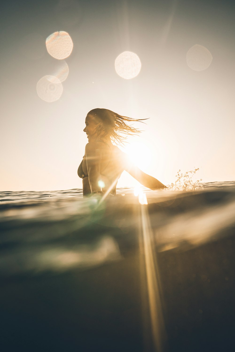 a woman riding a wave on top of a surfboard