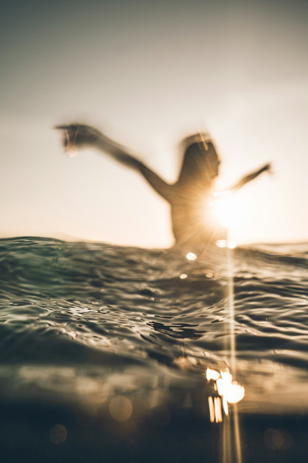 Person, die ihre Arme auf dem Meerwasser öffnet