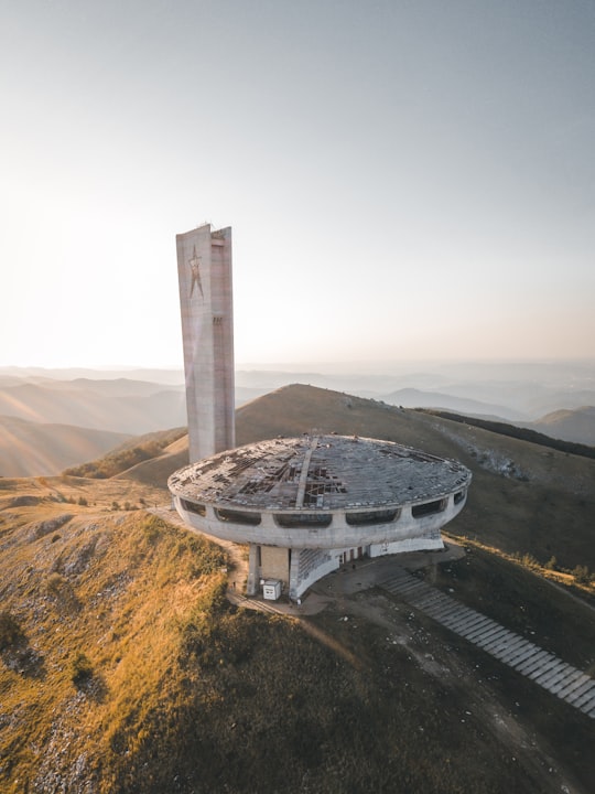 gray saucer shaped building in Buzludzha Bulgaria