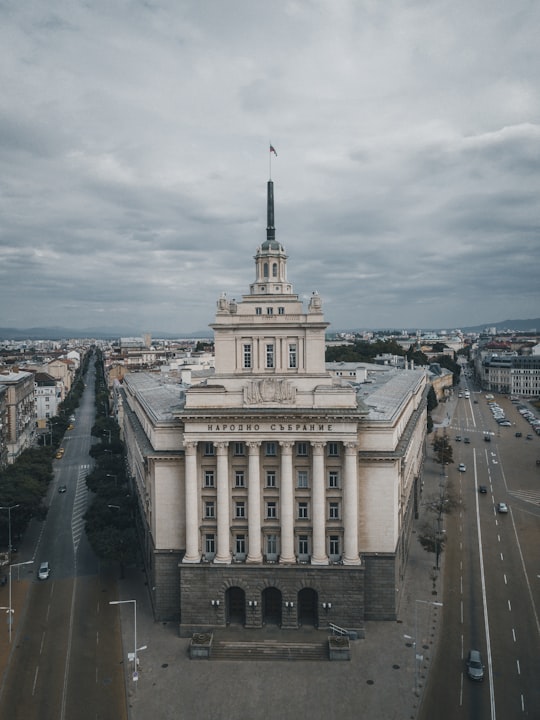 white and gray concrete building under cloudy sky in Former Communist Party House Bulgaria