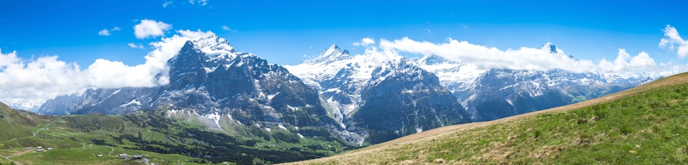 green mountain near snow-capped mountain