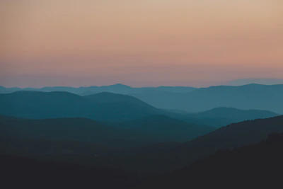 A serene landscape photograph by Studio Kavachi, capturing soft light over rolling hills.