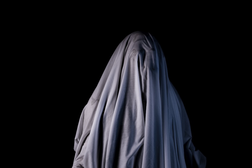 a ghostly figure in the dark with a black background